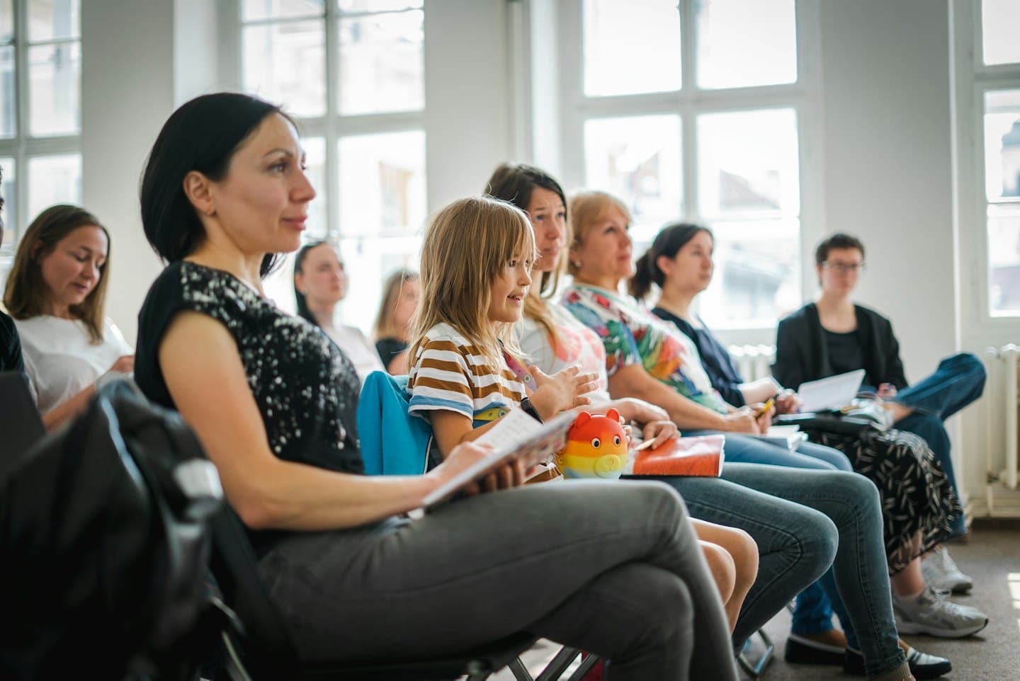 Girl gestures enthusiastically at an indoor business seminar.